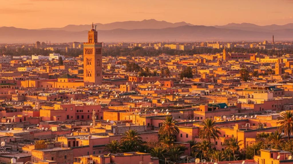 UK traveller in a Marrakech medina at golden hour checking a phone showing a connected mobile signal