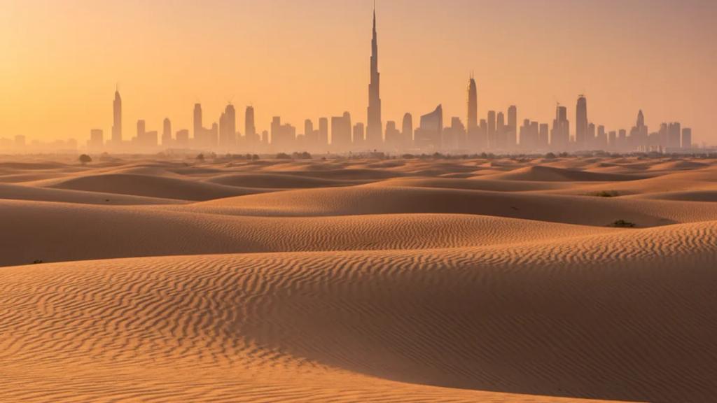 UK traveller by the Dubai skyline at dusk checking a phone showing a connected mobile signal