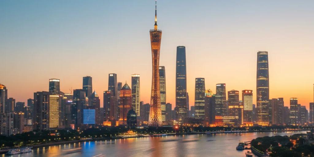 Canton Tower glowing in colour over the Pearl River at night, with the Zhujiang New Town skyline behind